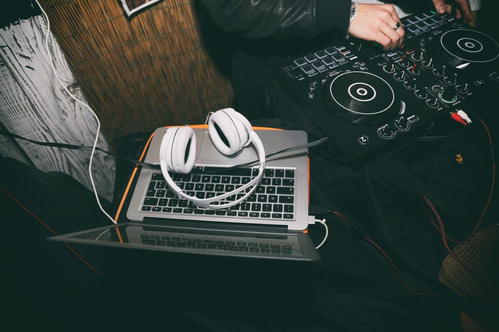 DJ using DJ equipment and white headphones